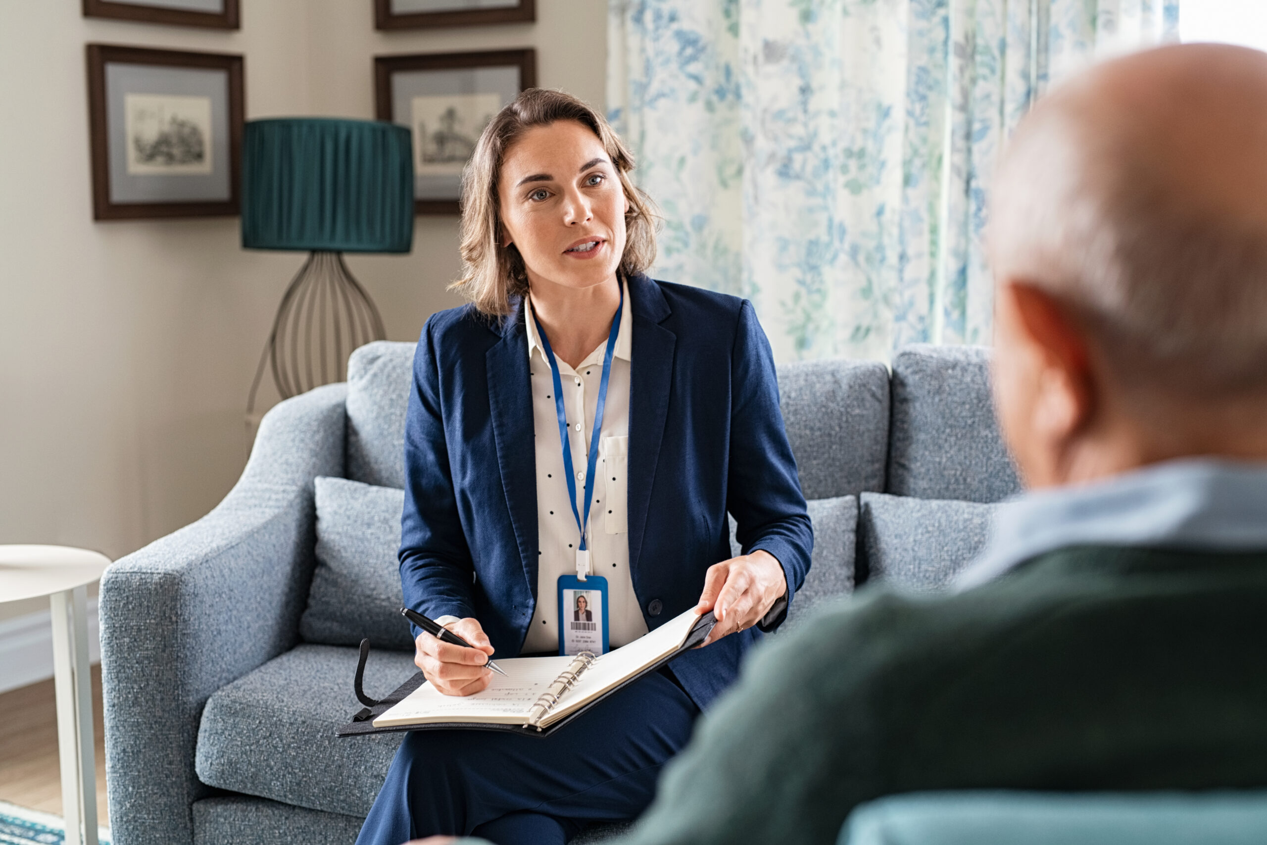 Mature social worker talking to senior man