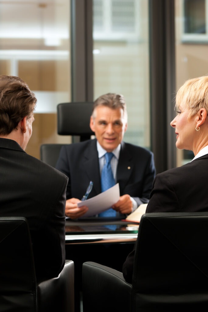 Mature lawyer or notary with clients in his office